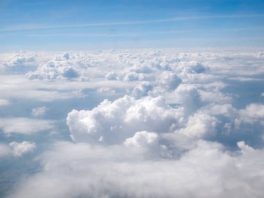 Mavi gökyüzü bulutlu, uçak penceresinden bir görünüm