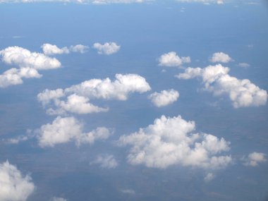Mavi gökyüzü bulutlu, uçak penceresinden bir görünüm
