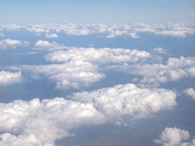 Mavi gökyüzü bulutlu, uçak penceresinden bir görünüm