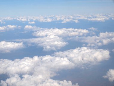 Mavi gökyüzü bulutlu, uçak penceresinden bir görünüm