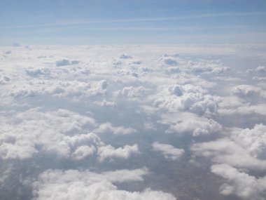 Mavi gökyüzü bulutlu, uçak penceresinden bir görünüm