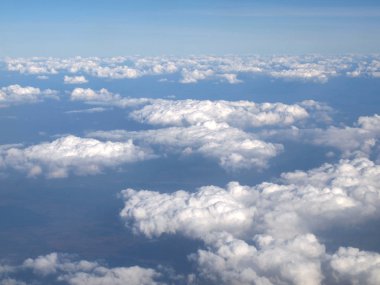 Mavi gökyüzü bulutlu, uçak penceresinden bir görünüm