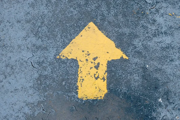 go straight yellow arrow on asphalt street