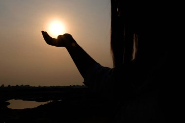 Sun on silhouette female hand.