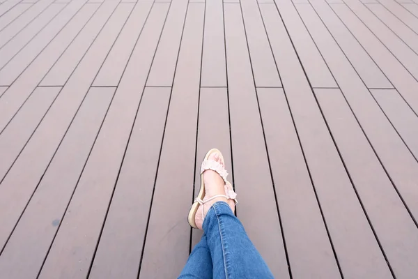 Женские ноги на деревянном фоне расслабляют — стоковое фото