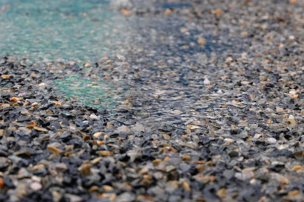 Gotas de chuva ondulando em uma poça — Fotografia de Stock