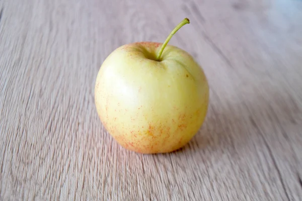 Chiudi mela rossa isolata su fondo legno — Foto Stock