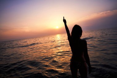 Genç kadın el canın cehenneme iz yaz aylarında günbatımı gösterir. Genç kadın ile orta parmak lanet gösteriş yapıyor