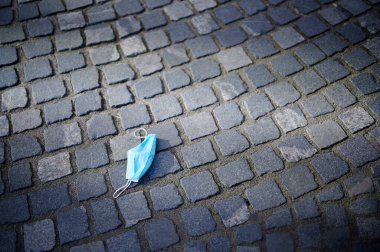 Antikorona virüsü için kullanılan kirli ve eski yüz maskesi çöp gibi sokakta yatıyor, Covid-19.