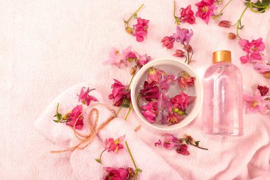 Pembe bornoz, aromaterapi, yaşam tarzı konsepti, davetiye için tebrik kartı üzerinde cilt ve vücut bakımı için kokulu orkide çiçekleri olan spa malzemeleri.