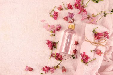 Cilt bakımı için yabani orkidelerin hoş kokulu çiçeklerinin bulunduğu spa malzemeleri, bornozda gül suyu ve havlu aromateryali, yaşam tarzı konsepti, davetiye kartı.