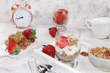 Yoğurtlu granola, taze çilek ve üzüm. Sağlıklı ve doğal yiyecek kavramı, bardaktaki diyet yararlı tatlı. Sağlıklı kahvaltı, çocuklar için yemek, seçici odaklanma..