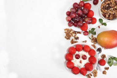 Yararlı kahvaltı, çocuklar için yemek, çilekli yoğurt, granola, süzme peynir, bal, mango, çilek ve üzüm. Sağlıklı ve doğal gıda kavramı. seçici odak, üst görünüm