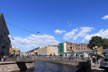 Rusya, Petersburg, 29 Haziran 2019. Bank Köprüsü 'nde kanatlı aslanlar. Fontanka Nehri 'ndeki Bank Köprüsü' ndeki Griffinler ve mimari şaheserlere hayran turistler