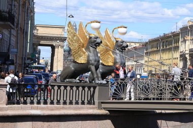 Rusya, Petersburg, 29 Haziran 2019. Bank Köprüsü 'nde kanatlı aslanlar. Fontanka Nehri 'ndeki Bank Köprüsü' ndeki Griffinler ve mimari şaheserlere hayran turistler