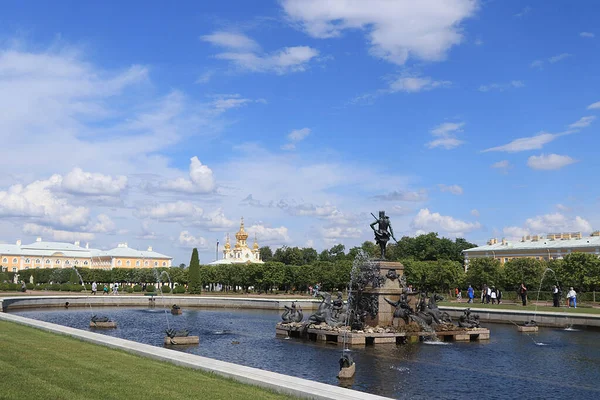 俄罗斯圣彼得堡彼得霍夫2019年7月8日图为位于国家博物馆保护区 彼得霍夫 上公园的喷泉 海王星 主教堂以及走进公园欣赏建筑的人们 — 图库照片