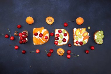 Süzme peynirli diyet meyve tostları, şeftaliler, üzümler ve kirazlar, malzemelerle sağlıklı kahvaltı. Sağlıklı ve doğal gıda konsepti, yaşam tarzı, düz yatak,