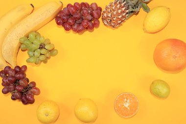 Sarı arka planda meyveler. Bağışıklığı, sağlıklı yaşam tarzını ve kilo kaybını, vitaminleri, diyet yemeklerini arttırmak için sağlıklı ve doğal gıdalar kavramı. Ekran için yaz afişi, metin için yer.