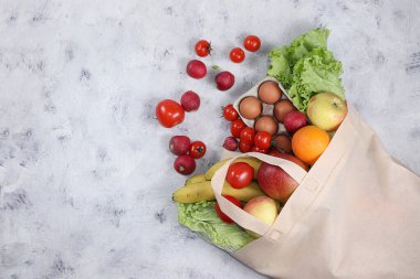 Eko torbadaki sağlıklı doğal yiyecek, sağlıklı yaşam tarzı kavramı, sıfır atık. Yemek teslimatı, bağış, koronavirüs karantinası. Sebzeler, doku paketindeki meyveler, diyet. Pankart