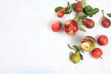 Elma ve armut şarabı, meyve suyu veya meyve suyu güneşli bir masada bir bardakta. Diyet ve kilo kaybı kavramı. Elmalar vücudu temizlemeye ve ağırlığı azaltmaya yardımcı olur. Sağlıklı beslenme,