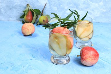 Elma ve armut şarabı, meyve suyu veya meyve suyu ve malzemeler güneşli bir masada. Diyet ve kilo kaybı kavramı. Elmalar vücudu temizlemeye ve ağırlığı azaltmaya yardımcı olur. Sağlıklı beslenme, seçici odaklanma