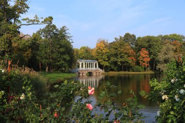 Rusya, St. Petersburg, 22 Eylül 2018, Catherine Park. Tsarskoye Selo 'daki Mermer Köprü' yü kırmızı yapraklı ve yansımalı bir sonbahar parkının arka planına karşı hayal ettim.