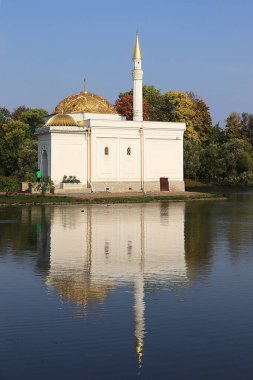 Rusya, St. Petersburg, 22 Eylül 2018, Catherine Park. Resimde, Tsarskoye Selo 'daki Türk Hamamı' nın bir sonbahar parkının arka planında kırmızı yapraklar ve gölde yansıması görülüyor.