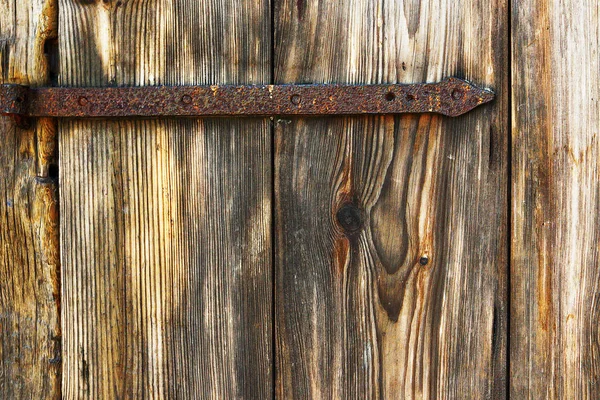 detail of spruce wood texture on old door with rusty metal hinge
