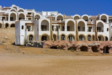 Sharm el-Sheikh, Mısır - 14 Mart 2018. Parçaları bir bitmemiş İnşaat ve Kızıldeniz sarı kum ve mavi gökyüzü arka plan üzerinde terk edilmiş bir otel. Geri kalanı üzerinde bir yaz günü açık havada seyahat.