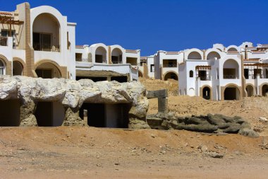 Sharm el-Sheikh, Mısır - 14 Mart 2018. Parçaları bir bitmemiş İnşaat ve Kızıldeniz sarı kum ve mavi gökyüzü arka plan üzerinde terk edilmiş bir otel. Geri kalanı üzerinde bir yaz günü açık havada seyahat.