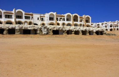 Sharm el-Sheikh, Mısır - 14 Mart 2018. Parçaları bir bitmemiş İnşaat ve Kızıldeniz sarı kum ve mavi gökyüzü arka plan üzerinde terk edilmiş bir otel. Geri kalanı üzerinde bir yaz günü açık havada seyahat.