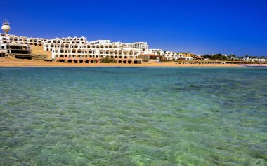 Sharm el-Sheikh, Mısır - 14 Mart 2018. Parçaları bir bitmemiş İnşaat ve Kızıldeniz sarı kum ve mavi gökyüzü arka plan üzerinde terk edilmiş bir otel. Geri kalanı üzerinde bir yaz günü açık havada seyahat.