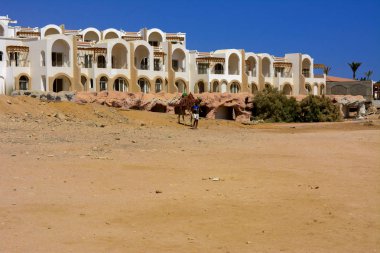 Sharm el-Sheikh, Mısır - 14 Mart 2018. Parçaları bir bitmemiş İnşaat ve Kızıldeniz sarı kum ve mavi gökyüzü arka plan üzerinde terk edilmiş bir otel. Geri kalanı üzerinde bir yaz günü açık havada seyahat.