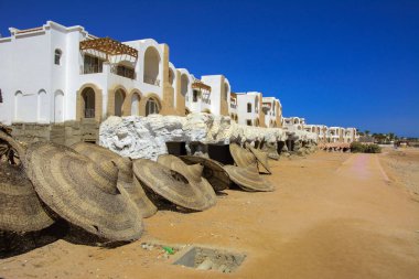 Sharm el-Sheikh, Mısır - 14 Mart 2018. Parçaları bir bitmemiş İnşaat ve Kızıldeniz sarı kum ve mavi gökyüzü arka plan üzerinde terk edilmiş bir otel. Geri kalanı üzerinde bir yaz günü açık havada seyahat.