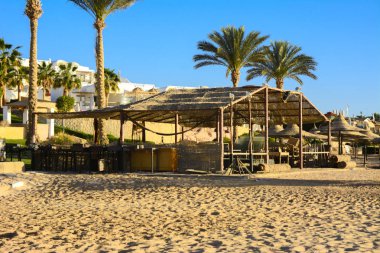 Çocuk ahşap oyun grupları boş bir sahil sarı kum ve mavi gökyüzünün bir arka plan üzerinde terk edilmiş. Atılmış, gereksiz şeyler. Tatil, turizm.