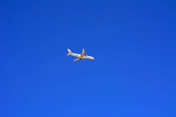 大型の旅客機は 青い空に高く飛び — ストック写真