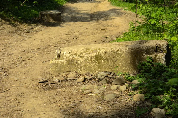 A large building block for the foundation thrown on an old dirt road on the edge of the forest. The foundation of the house, the foundation for a new building.