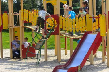 Khust, Ukrayna - 22 Nisan 2018. Küçük çocuklar etrafında koşmak ve oyun alanında oynamak. Genç bir çocuk oyun merkezi. Küçük kız açık havada oynuyor. Yaz çocuk eğlence kavramı.