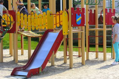 Khust, Ukrayna - 22 Nisan 2018. Küçük çocuklar etrafında koşmak ve oyun alanında oynamak. Genç bir çocuk oyun merkezi. Küçük kız açık havada oynuyor. Yaz çocuk eğlence kavramı.