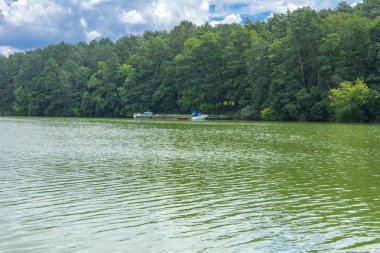 Manzara çevrili ağaçlar ve kıyı ve mavi gökyüzünde bulutlar karşı uzak ufuk sazlık nehir ortasından güzel bir görüntüsü. Yansıma, su, Turizm hedef