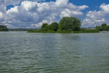 Manzara çevrili ağaçlar ve kıyı ve mavi gökyüzünde bulutlar karşı uzak ufuk sazlık nehir ortasından güzel bir görüntüsü. Yansıma, su, Turizm hedef