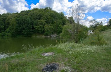 Yoluyla ve liken ve moss bir arka plan mavi bir gökyüzü ve yeşil bitki örtüsü ile kaplı kaya şelale Nehri akar.