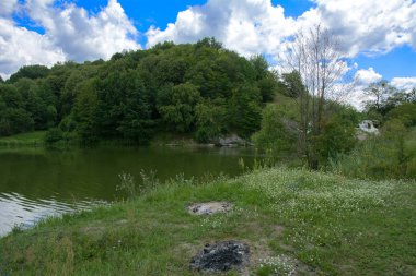 Yoluyla ve liken ve moss bir arka plan mavi bir gökyüzü ve yeşil bitki örtüsü ile kaplı kaya şelale Nehri akar.