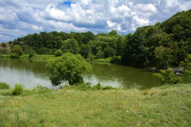 Yoluyla ve liken ve moss bir arka plan mavi bir gökyüzü ve yeşil bitki örtüsü ile kaplı kaya şelale Nehri akar.