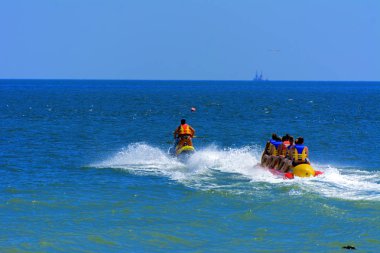 Odessa, Ukrayna - 8 Ağustos 2018. Turistler eğleniyor ve scooter deniz yoluyla taşıma kırmızı ve sarı şişme muz, binme keyfini çıkarın. Yaz tatili, tatil ve seyahat kavramı