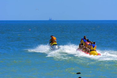 Odessa, Ukrayna - 8 Ağustos 2018. Turistler eğleniyor ve scooter deniz yoluyla taşıma kırmızı ve sarı şişme muz, binme keyfini çıkarın. Yaz tatili, tatil ve seyahat kavramı