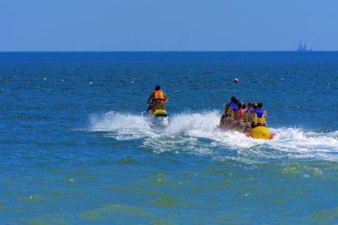 Odessa, Ukrayna - 8 Ağustos 2018. Turistler eğleniyor ve scooter deniz yoluyla taşıma kırmızı ve sarı şişme muz, binme keyfini çıkarın. Yaz tatili, tatil ve seyahat kavramı