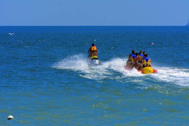 Odessa, Ukrayna - 8 Ağustos 2018. Turistler eğleniyor ve scooter deniz yoluyla taşıma kırmızı ve sarı şişme muz, binme keyfini çıkarın. Yaz tatili, tatil ve seyahat kavramı