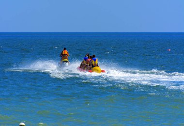 Odessa, Ukrayna - 8 Ağustos 2018. Turistler eğleniyor ve scooter deniz yoluyla taşıma kırmızı ve sarı şişme muz, binme keyfini çıkarın. Yaz tatili, tatil ve seyahat kavramı