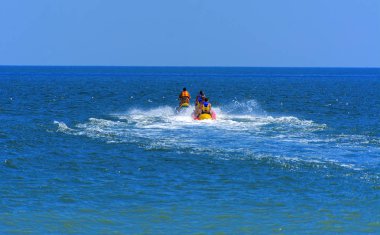 Odessa, Ukrayna - 8 Ağustos 2018. Turistler eğleniyor ve scooter deniz yoluyla taşıma kırmızı ve sarı şişme muz, binme keyfini çıkarın. Yaz tatili, tatil ve seyahat kavramı